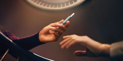 أيد تقوم بفتح جهاز IQOS ILUMA i PRIME باللون النبيتي