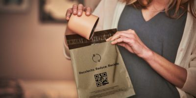 Manos recibiendo una caja de un Dispositivo IQOS de otras manos.