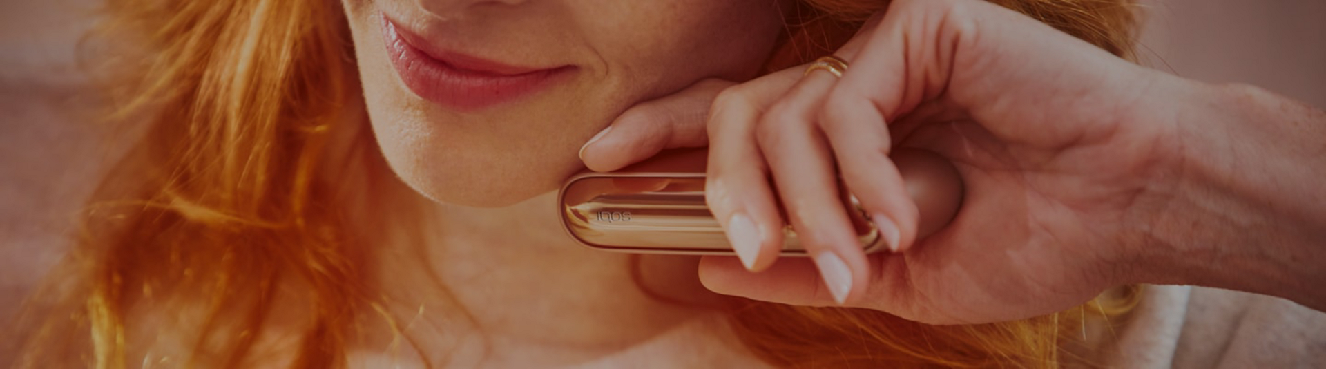 Blond girl with her gold IQOS kit in her hands