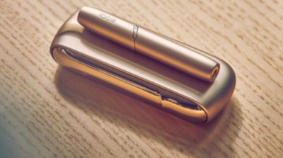 Gold IQOS DUO on a laptop