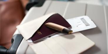 Gold IQOS VEEV and a passport on a table