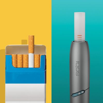 IQOS Originals Duo holder with heat stick, next to a cigarette pack.