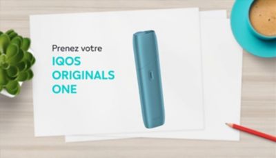 Appareil IQOS ORIGINALS ONE en turquoise à côté du chargeur de câble.