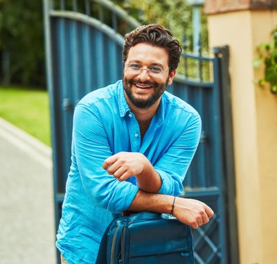 A woman looking at the back of an IQOS box. 