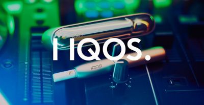 A man holding an IQOS device embraces his partner.