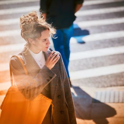 Woman on the street using an IQOS holder