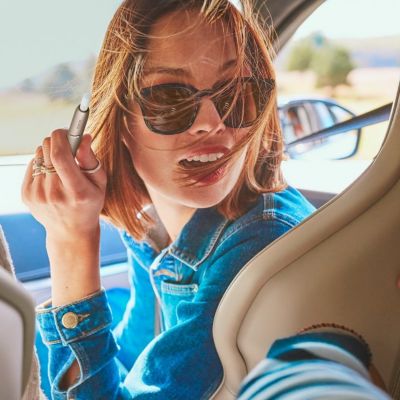 Woman in a car with IQOS holder in her hand