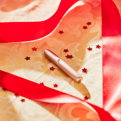 Stylet IQOS 3 DUO doré sur un tissu avec étoiles rouges 