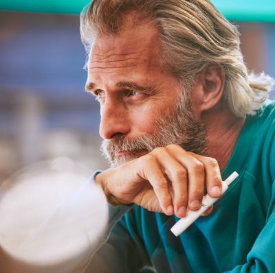 Man with white IQOS holder in his hand