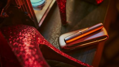 Un appareil IQOS a coté d'une chaussure à talons