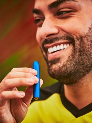 A drag queen holding an IQOS device.