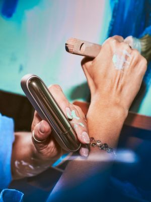 La main d'un artiste qui tient un IQOS