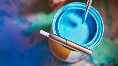 An artist using her IQOS device.