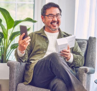 A smiling man holdiing an IQOS device.