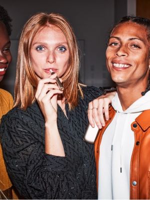 رجل يبتسم وهو يحمل جهاز IQOS. 