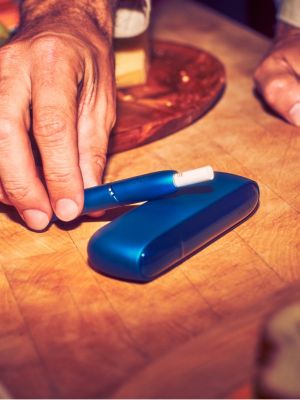 A blue IQOS device and holder.