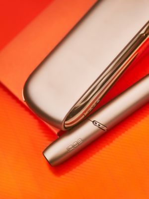 A gold IQOS device and holder.