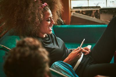 Friends on a sofa, watching television.