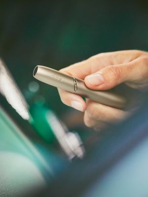 Brilliant gold IQOS 3 DUO holder with HEETS stick in hand