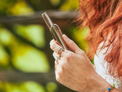 Brilliant gold IQOS 3 DUO and charger in hand