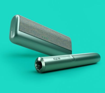 A jade green IQOS ILUMA PRIME holder and a matching device with a TEREA stick inserted.