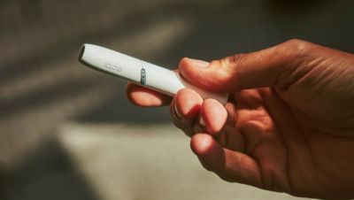 A person holding an IQOS device.