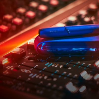 Stellar blue IQOS 3 DUO holder and charger on a music production panel