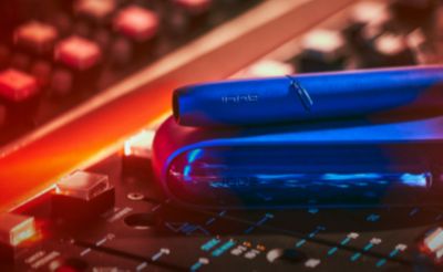 Stellar blue IQOS 3 DUO holder and charger on a music production panel