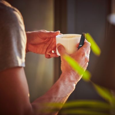 Stellar blue IQOS 3 DUO and a cup in man's hands