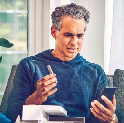 Man in blue jumper unboxing a new IQOS device