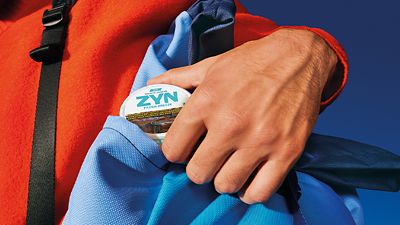Man pulling out a ZYN can from his blue bag