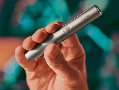 An IQOS ILUMA device in a person's hand.