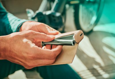 An IQOS ILUMA PRIME in a person's hands.