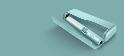 IQOS Iluma i azul en posición diagonal sobre fondo verde menta.