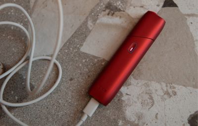 IQOS ORIGINALS ONE Scarlet lädt mit originalem Ladekabel.