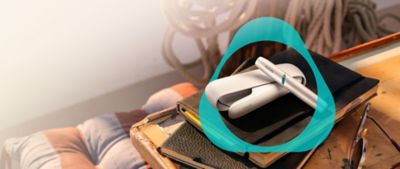 IQOS ORIGINALS DUO Gerät neben Sonnenbrille.
