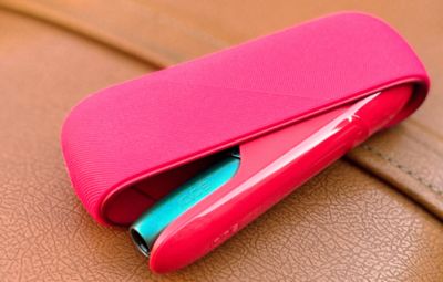 Appareil IQOS doré placé sur une surface noire