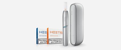 Two women looking at a light blue IQOS device