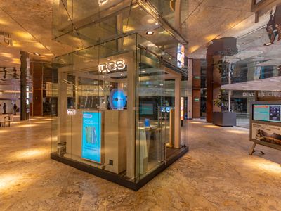 Estructura con arcos turquesa mostrando diferentes dispositivos IQOS ILUMA.