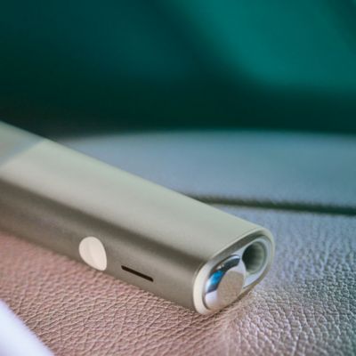 Woman holding an IQOS ILUMA ONE device