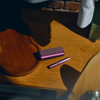 Mesa con IQOS Iluma i Prime morado y un IQOS Iluma i verde.