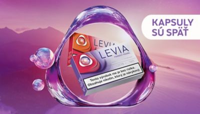 Dve krabičky nikotínových náplní LEVIA v rôznych príchutiach - s logom IQOS - na pozadí rieka a západ slnka.