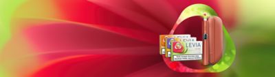 Zariadenie IQOS ILUMA a 3 krabičkz náplní LEVIA na farebnom pozadí
