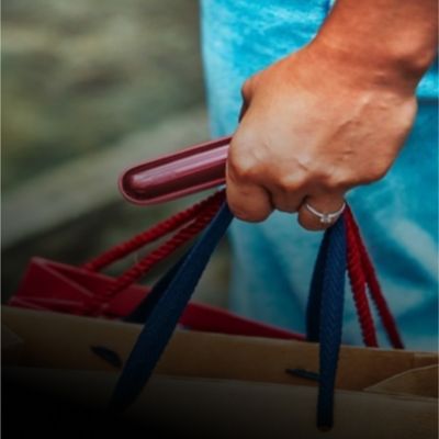 Červené zariadenie IQOS ILUMA  v ruke.