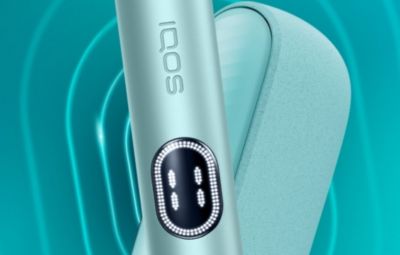 Gros plan sur un appareil IQOS ILUMA i MID présenté sur un fond aux dégradés bleus avec un motif concentrique.