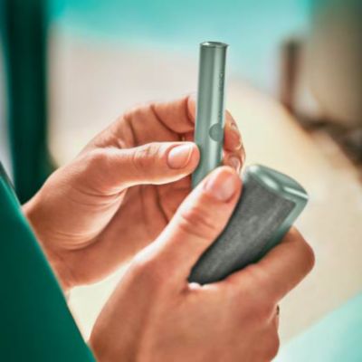 Brilliant gold IQOS 3 DUO holder and charger in hand