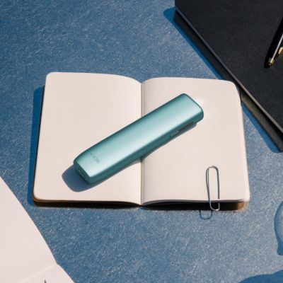 A person holding an IQOS ILUMA ONE.