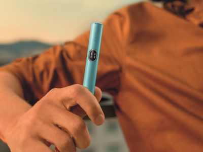 Close-up of hands holding an IQOS device.