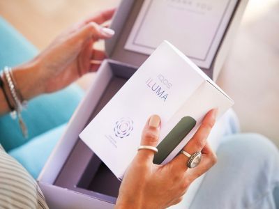 A woman unboxing an IQOS box