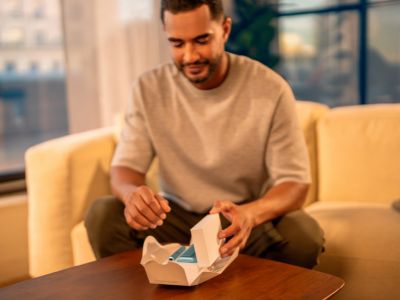 A man unboxing an IQOS packaging.